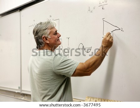 A middle aged man going back to school, or a teacher writing on the board.