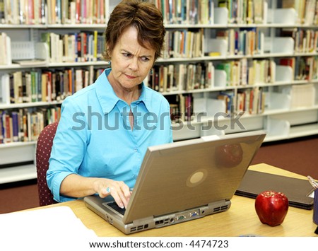 A school librarian frowns as she reviews students on-line activity.