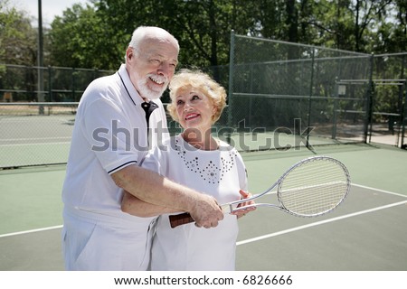 Senior man gives his wife pointers on tennis.