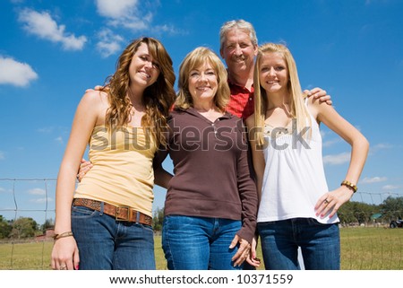 Grandparents and their beautiful teen granddaughters outside on the farm.