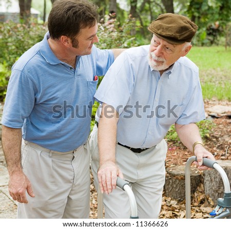 Adult son out for a walk with his father, who has alzheimers disease.