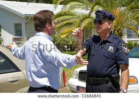 Police officer giving a sobriety test to a drunk driver.