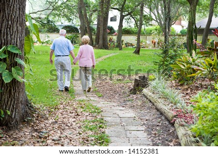 Senior couple strolling down a garden path together.  A metaphor for life\'s journey.