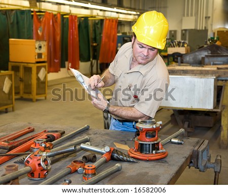 Inspector verifying the condition of available tools in a metal work shop.  Authentic and accurate content in accordance with industry code and safety standards.