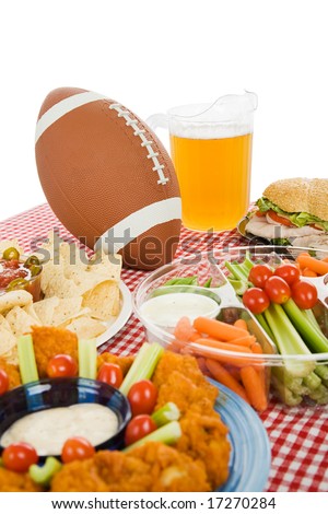Table set with snack foods for a Super Bowl party.  (focus on football) Vertical view with white background.