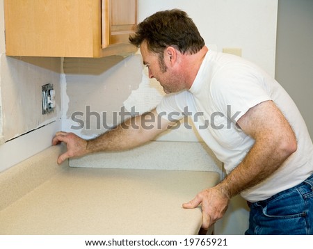 Contractor installing a laminate counter top during a kitchen remodel project.