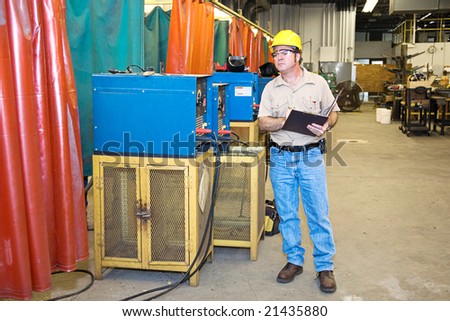 Inspector checking the welding equipment in a metal works factory.