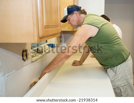 Contractor installing laminate counter top during a kitchen remodel.