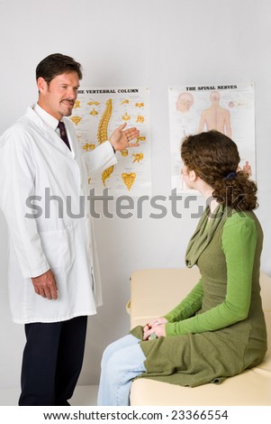 Chiropractor explaining the spine and nervous system to a new patient.