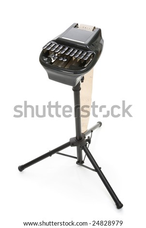 Isolated view of a stenography machine used in court reporting, on a tripod.