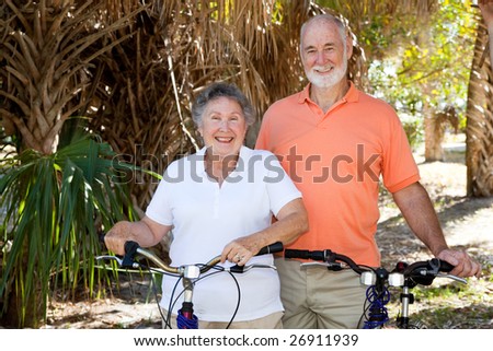 Active senior couple in the park with their bicycles.