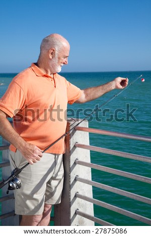 Senior man preparing to bait his fishing hook and catch some fish.