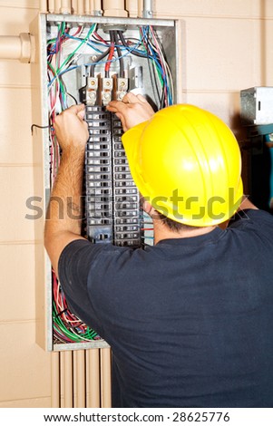 Electrician replacing a bad circuit breaker in a large industrial panel.