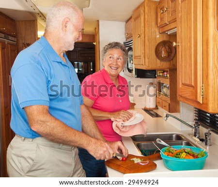 Retired senior couple in the kitchen of their RV camper.