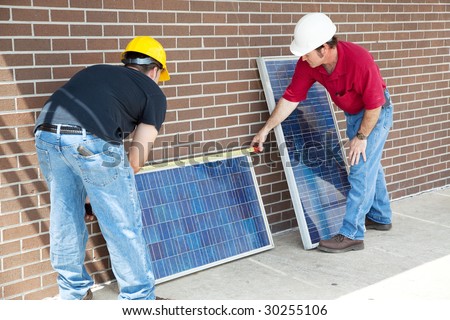Electricians measuring solar panels prior to installing them.