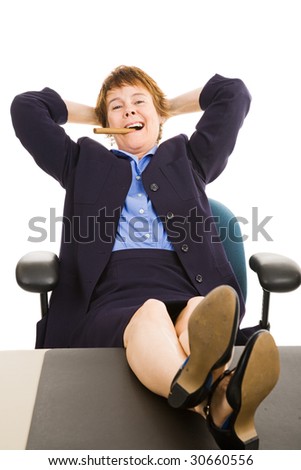 stock photo Mature businesswoman smoking a cigar with her feet on her desk