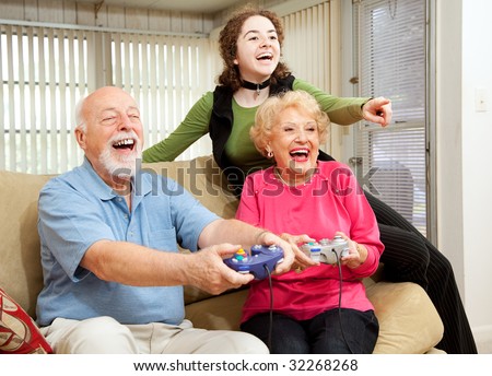 Grandparents and teen girl having fun playing video games.