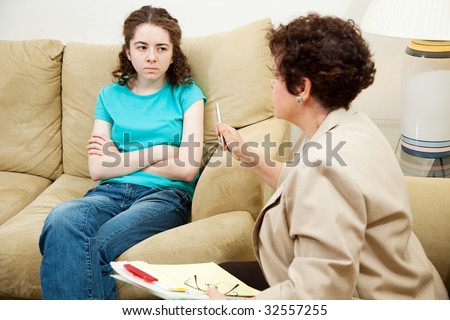 Angry, rebellious teen girl talking to a counselor.