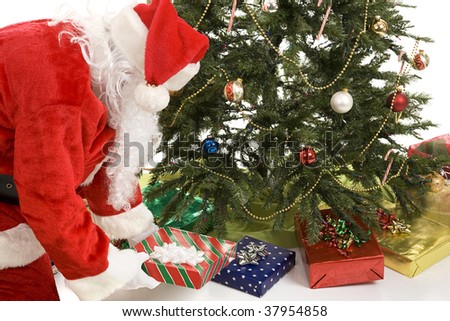 Santa Claus putting gifts under the Christmas tree.  White background.