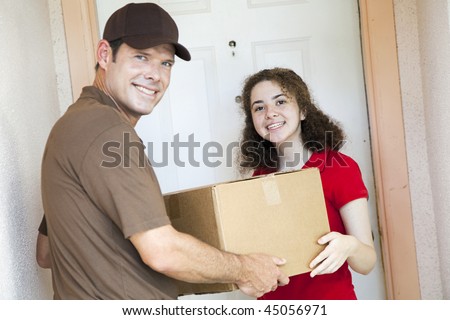 Happy customer receiving a package from a delivery man.  Focus on girl.
