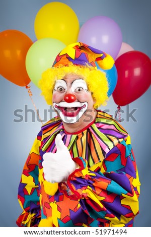 Happy clown with balloons giving thumbs up sign.