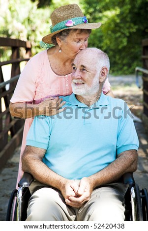 Senior woman caring for her disabled husband.