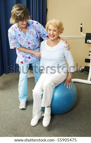 Physical therapist helps a senior woman exercise on a pilates ball.