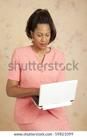 Beautiful african american businesswoman checks email on her wireless netbook computer.