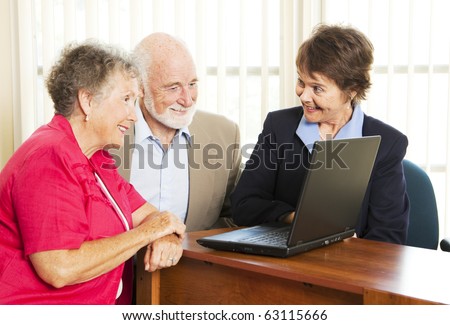 Persuasive sales woman pitches financial services to an elderly couple.