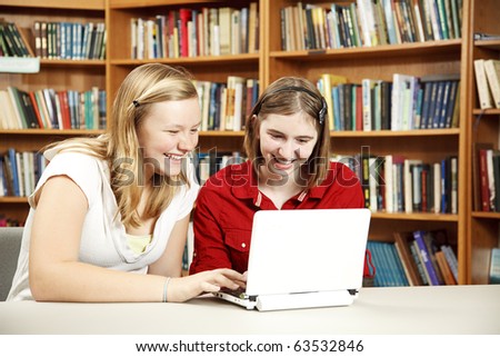 Teen girls using a netbook to do research in the library.  Room for Text