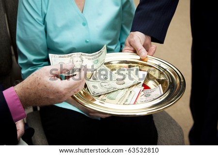 Church members putting money in the collection plate.