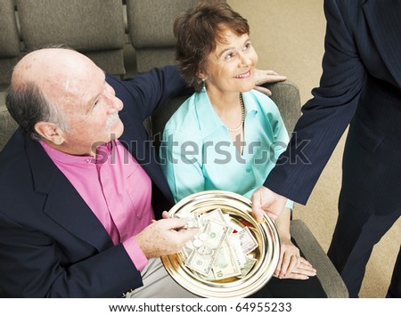 Church members placing money in the collection plate.
