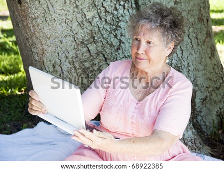 Senior woman trying to use a netbook computer and getting frustrated.