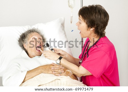 Hospital nurse uses and otoscope and tongue depressor to examine a patient.