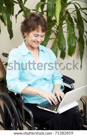 Disabled businesswoman using a tiny netbook computer.