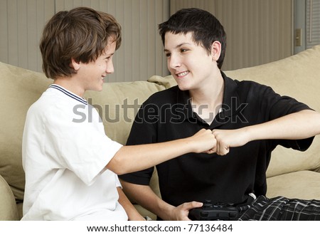 Teen and his younger brother giving each other an affectionate fist bump.