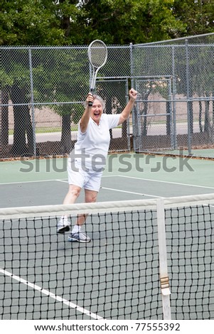 Senior woman excited about winning a tennis match.