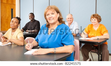 Mature woman in college, among a group of other adult students.   Banner orientation.