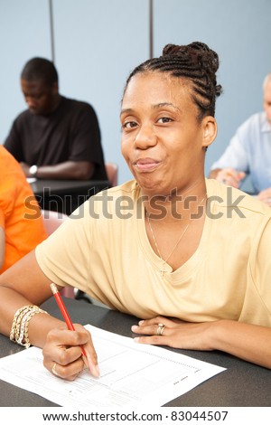 Pretty college student with Cerebral Palsy, taking a test in her adult education class.