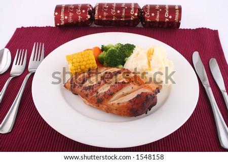 Meal setting for chicken and vegetable dinner with christmas decorations