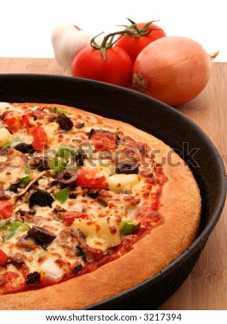 A supreme pizza in a pan with mixed vegetables