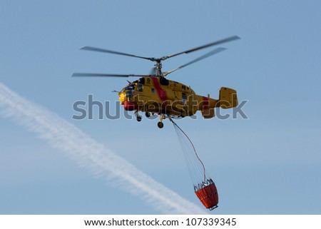 AVELAR, PORTUGAL - JULY 7 : Fire rescue heavy helicopter, with water bucket, preparing for water scooping to combat a fire in Avelar July 7, 2012 in Avelar, Portugal