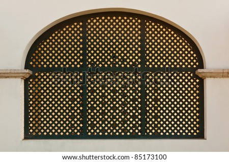 Old arch metal grid window on white wall