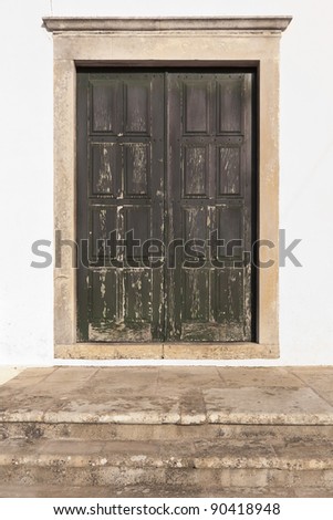 Old stained green double door with stone stairs