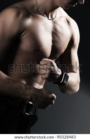 stock photo Perfect naked male torso with a clock in his hand against 