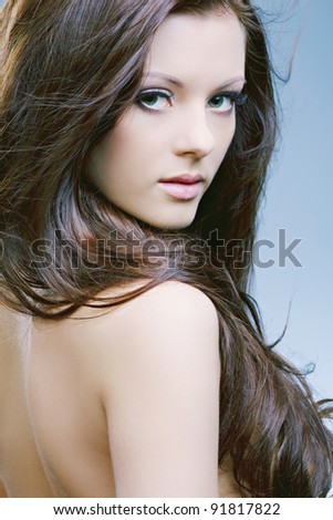beautiful woman with perfect skin and long dark luxuriant hair on a dark background