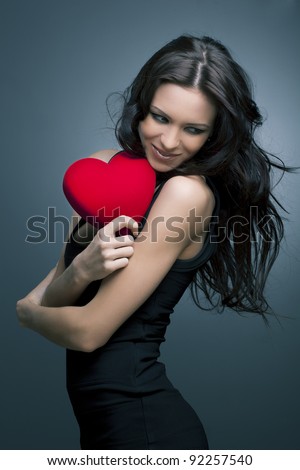 Valentine\'s Day. Beautiful smiling woman with a gift in the form of heart in his hands