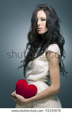 Valentine\'s Day. Beautiful woman with a gift in the form of heart in his hands