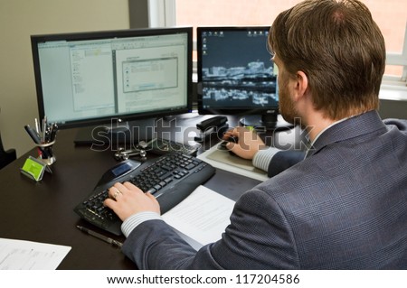 Business man in suit, working at a desk on his computer.