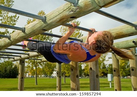 Young woman doing Australian Pull-ups on a jungle gym.